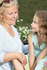 Grandmother with her granddaughter spending time together in the garden