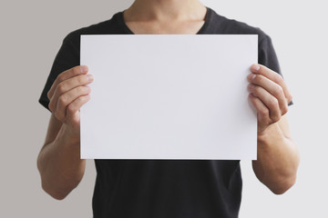 Man holding white A4 paper horizontally