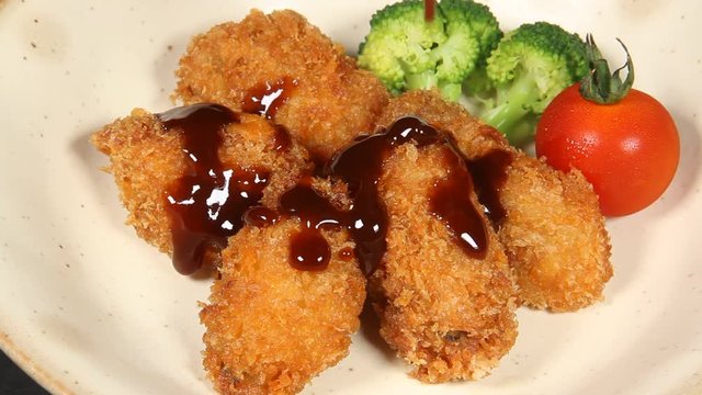 かきフライにソースをかける