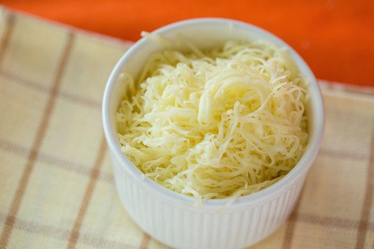 Grated cheese in a white bowl