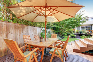 House exterior. Wooden patio table set with umbrella
