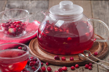 Cranberry tea in a glass cup and teapot