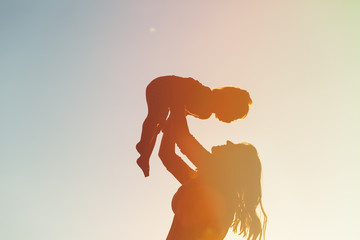 Naklejka premium mother and little daughter play at sunset