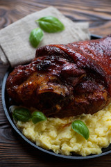 Close-up of roasted pork knuckle served with mashed potato