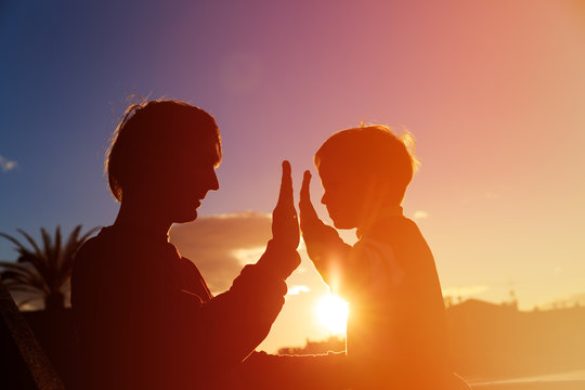 father and son playing at sunset sky