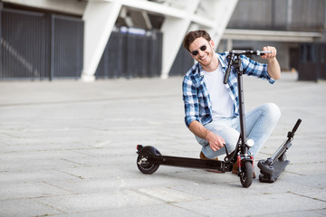 Positive man holding kick scooter
