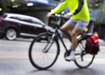 Fototapeta na wymiar Blurred image of a cyclist riding through the city
