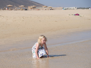 kleines blondes Mädchen rennt am strand