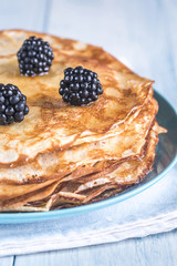 Crepes with blackberries on the wooden table