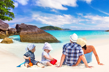 Family with twins on sun holidays at the tropical beach