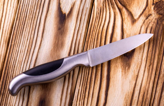shiny metal kitchen knife on a wooden table