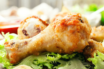 Fried chicken leg on lettuce leaves