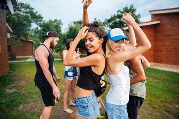 Fototapeta premium Young cheerful happy teens dancing at the picnic area