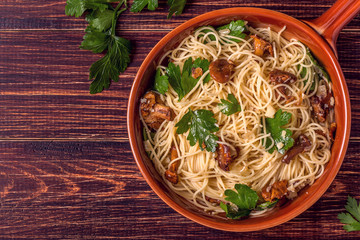Pasta spaghetti with chanterelles mushrooms on wooden background