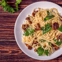 Pasta spaghetti with chanterelles mushrooms on wooden background
