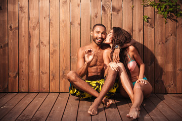 Happy cheerful mixed race couple showing okay gesture