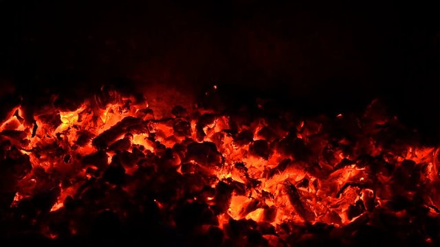 Glowing coals in the fireplace. Closeup. UHD - 4K