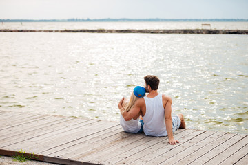 Loving couple on the beach hugging while looking at sea