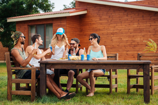 Smiling People Drinking Beer And Soda At The Table Outdoors