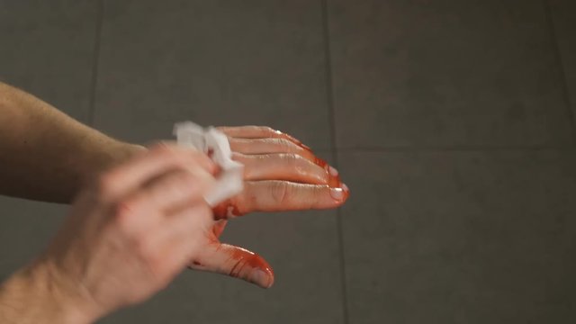 man treats cure his injured bloody hand after an accident