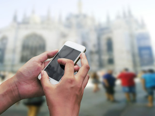Hand hold and touch screen smart phone,on city blur.