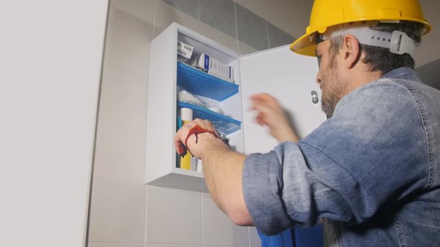 injured workman opening a first aid kit to treats cure medicate his  bloody  hand 