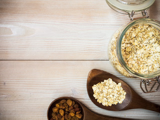 Glass jar with oat-flakes on the wooden background. View from above