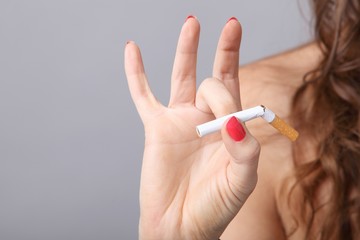 Durchgebrochene Zigarette in der Hand einer Frau