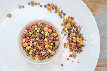 Bowl of various pepper on white plate