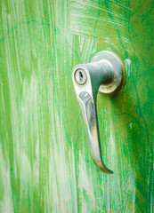 old rustic door handles or door knob against green metal plate background