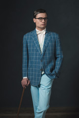 Retro 1920s fashion man wearing blue checkered jacket. Standing