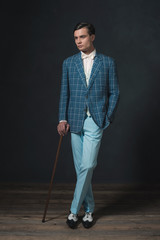 Vintage 1920s well dressed young man standing with cane.