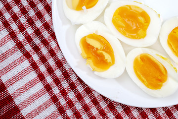 Boiled eggs in white plate on the red napkin