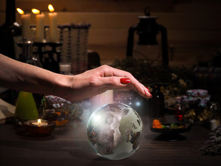 Female hand on the magic sphere. Silhouette of a ghost in  bowl. Flasks, retort for alchemy. Concept - occult, esotericism, spiritualism, calling the spirits and ghosts, underworld