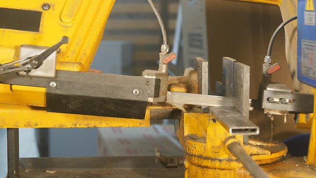 sawing metal steel bar in a  workshop with industrial circular saw  close up