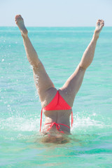 Bikini woman underwater handstand ocean