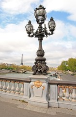Fototapeta na wymiar Candélabre du pont Alexandre III, 19 ème siècle, au loin la Tour Eiffel (Paris France)