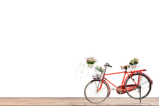 Old red bicycle with flower in basket on wood , white background