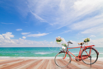 Fototapeta na wymiar Old bicycle on wood with Turquoise sea , beautiful sea beach 