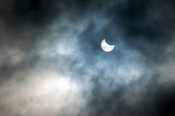 Naklejka na ściany i meble The solar eclipse on cloudy sky