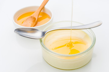 Honey jet falls on homemade custard, isolated