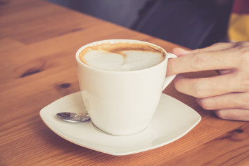 Retro tone of coffee cup with hand holding 