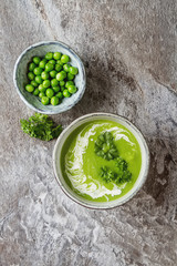 Pea soup puree in an old plate with parsley decoration. Stone sl