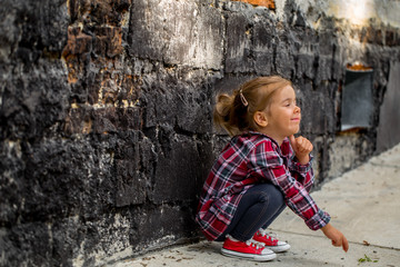 little beautiful girl near brick wall