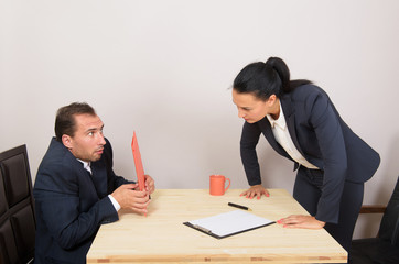 Angry businesswoman reproaching afraid man at work in the office