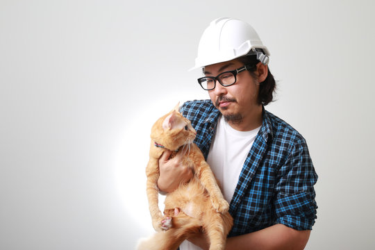 The Asian man standing on the white background.