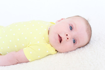 Portrait of 2 months baby girl in yellow bodysuit