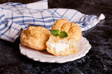 Eclairs with vanilla cream on a white plate