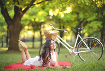 Obraz premium Young beautiful woman reading book outdoors in park on a sunny d