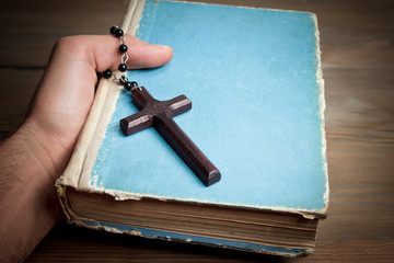 Book and cross in the hand